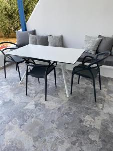 阿吉奥斯普罗科皮奥斯尼克莱塔一室公寓酒店的一张白色的桌子和两把椅子以及一张沙发