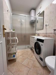 赫瓦尔Villa Hosta Apartments的带淋浴的浴室内的洗衣机