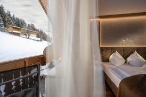 瓦尔道拉Almhotel Lenz的一间卧室设有一张床和一个美景窗户。