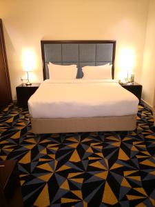 吉达Ocean View Al Zahra的一间卧室配有一张大床和两张台灯。