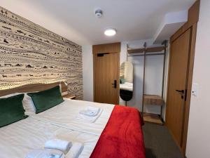 霍宁斯沃格Arctic Hotel Nordkapp的卧室配有带绿色枕头的大型白色床