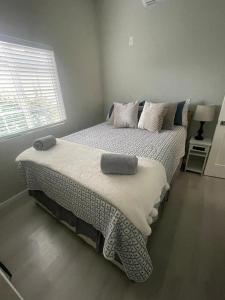 洛杉矶Van Nuys Luxury, near to Universal Studios, and Hollywood的卧室配有带枕头的床铺和窗户。