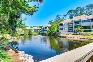 希尔顿黑德岛Dog Friendly Palmetto Dunes Condo, 2 Mi to Beach!的一条河,在一些公寓楼前