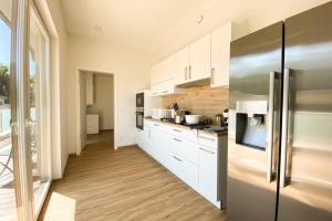 博福特310 Lux Furnished flat的厨房配有白色橱柜和不锈钢冰箱