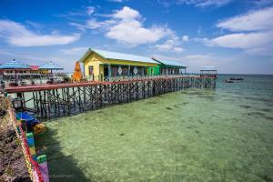 Derawan IslandsMirroliz Pelangi Cottage的水中码头上的建筑物