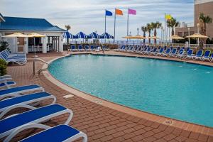 弗吉尼亚海滩万豪弗吉尼亚海滩海滨春丘套房酒店的一个带蓝色椅子和遮阳伞的游泳池