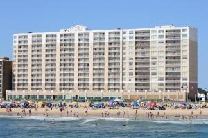 弗吉尼亚海滩万豪弗吉尼亚海滩海滨春丘套房酒店的海滩上一座大型建筑,有一群人