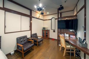 成田Grand Hotel Narita Airport - Vacation STAY 56496v的一间设有两把椅子、一张桌子和一台电视的房间