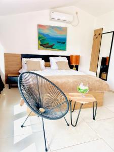 奥赫里德拉贾丁酒店的一间卧室配有一张床、一把椅子和一张桌子