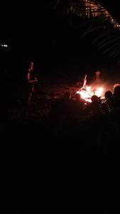 劳托卡Lusis Homestay的一群人晚上站在火炉旁