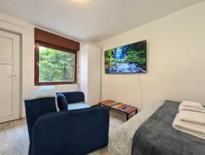 赛斯韦泰Cozy Room w A/C, 65'' TV & Floor Heating的卧室配有床、椅子和窗户。