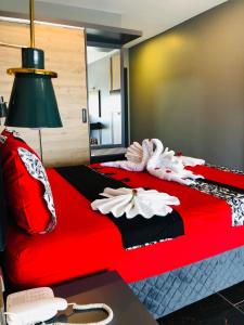 PelitliBurç Otel的一间卧室配有红色的床和毛巾