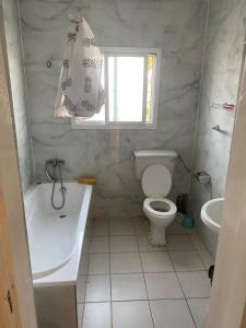 Ker BakaryHarmony house apartments的浴室配有卫生间、浴缸和水槽。