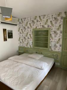 因特拉尼亚Hotel Antico的卧室配有白色床和花卉壁纸