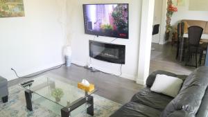 多伦多Richview Gardens Suite的客厅配有沙发和墙上的电视