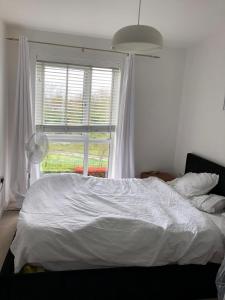 奥平顿Impeccable 2-Bed Apartment in Orpington的卧室内的一张床铺,设有大窗户