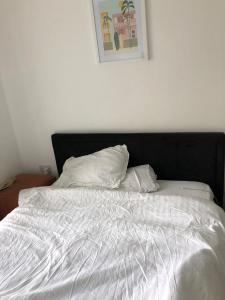 奥平顿Impeccable 2-Bed Apartment in Orpington的一张带黑色床头板的白色床和两个枕头