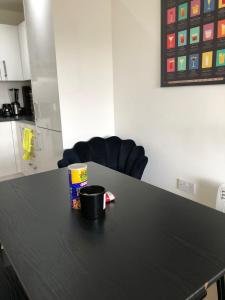 奥平顿Impeccable 2-Bed Apartment in Orpington的一张黑色桌子,上面有咖啡杯