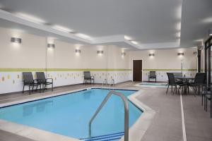 苏福尔斯费尔菲尔德客栈及套房万豪苏福尔斯机场酒店的一个带桌椅的房间的游泳池