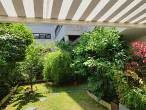 库尔布瓦LONG STAY Courbevoie charmant Apt T3 avec jardin et terrasse, calme, proche transports的一座种植了树木和植物的花园