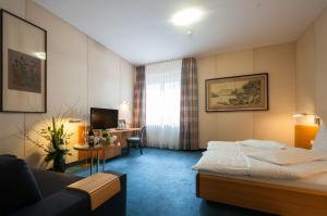 斯图加特乌恩基尔酒店的配有一张床和一张书桌的酒店客房