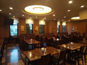弘前市弘前城东路线酒店的用餐室配有木桌和椅子