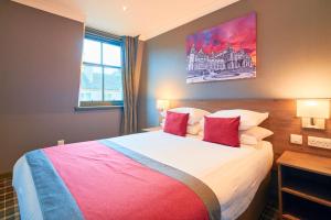 格拉斯哥Best Western Glasgow Hotel的一间卧室配有一张大床和两个红色枕头
