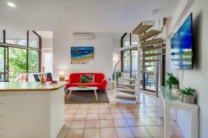 努萨角海风度假酒店的一间带红色沙发的客厅和楼梯
