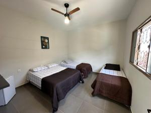 德尔菲诺波利斯casa inteira com 3 suites e área de lazer的客房设有两张床和吊扇。