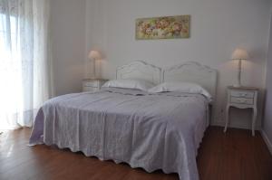 托尔维加塔丽贝卡住宿加早餐旅馆的一间卧室配有一张带白色床罩和2个床头柜的床