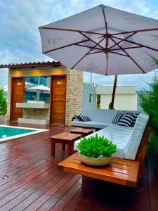 巴纳伊巴Apartamento localizado em condomínio fechad0 em Barra Grande - PI的平台上设有带沙发和遮阳伞的天井。