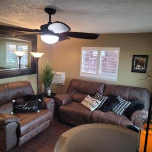 科迪Mountain View Lodging Cody的客厅配有2张棕色皮沙发