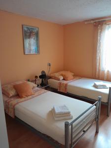 波斯蒂拉Apartments with a parking space Postira, Brac - 2911的橙色墙壁客房中的两张单人床