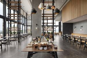 约翰内斯堡Marriott Executive Apartments Johannesburg, Melrose Arch的餐厅设有木桌、椅子和窗户。