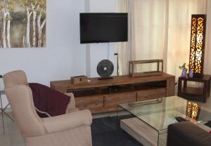 卡萨内Sunbirds Chobe Hotel的客厅配有电视、沙发和桌子