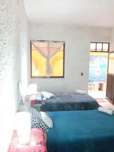 乌尤尼salt beds of salt hostal的一间卧室设有两张床和窗户。