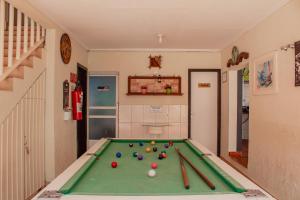 伊瓜苏波萨达伊瓜苏套房旅馆的一间设有台球桌、球和 ⁇ 蝠的房间
