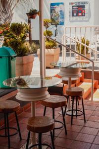 伊瓜苏波萨达伊瓜苏套房旅馆的种植了植物的庭院里设有两张桌子和凳子