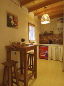 奇莱西托Cabaña "Amanecer"的厨房配有木桌和凳子