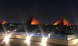 开罗Nine Pyramids View Hotel的享有一座金字塔建筑的夜间景色