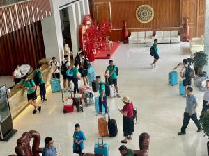 波来古市特雷先酒店的一群人站在大堂,带着行李