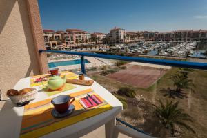 滨海阿热莱斯阿尔格里斯美尔&高尔夫港口公寓的阳台配有桌子,享有海港景色