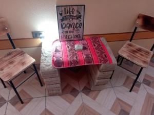 乌尤尼Hostal Beds of salt Ga的一张桌子,上面有两把椅子和标志