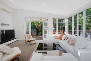 奥克兰Urban Oasis in Remuera, Auckland的客厅配有白色家具和窗户。