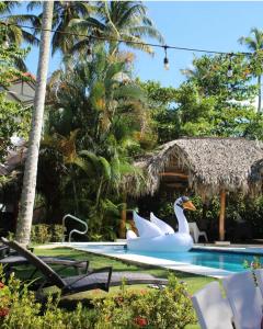 拉斯特拉纳斯VillasMana Complex PlayaBonita LasTerrenas Samana NearBeach WiFi的度假村内带两个天鹅的游泳池