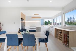 奥克兰Urban Oasis in Remuera, Auckland的厨房配有木桌和蓝色椅子