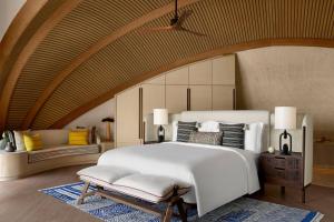 ḨanakNujuma, a Ritz-Carlton Reserve的卧室配有一张白色的大床和一张沙发。