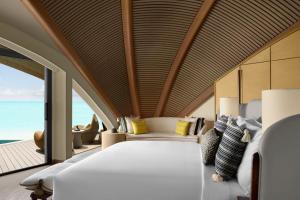 ḨanakNujuma, a Ritz-Carlton Reserve的一间卧室设有一张大床,享有海景