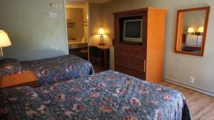 橙县Executive Inn & Suites的酒店客房设有两张床和电视。