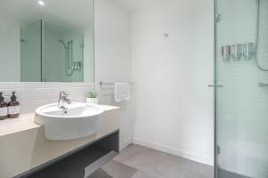 凯恩斯325 Harbour Lights with Garden View的白色的浴室设有水槽和淋浴。